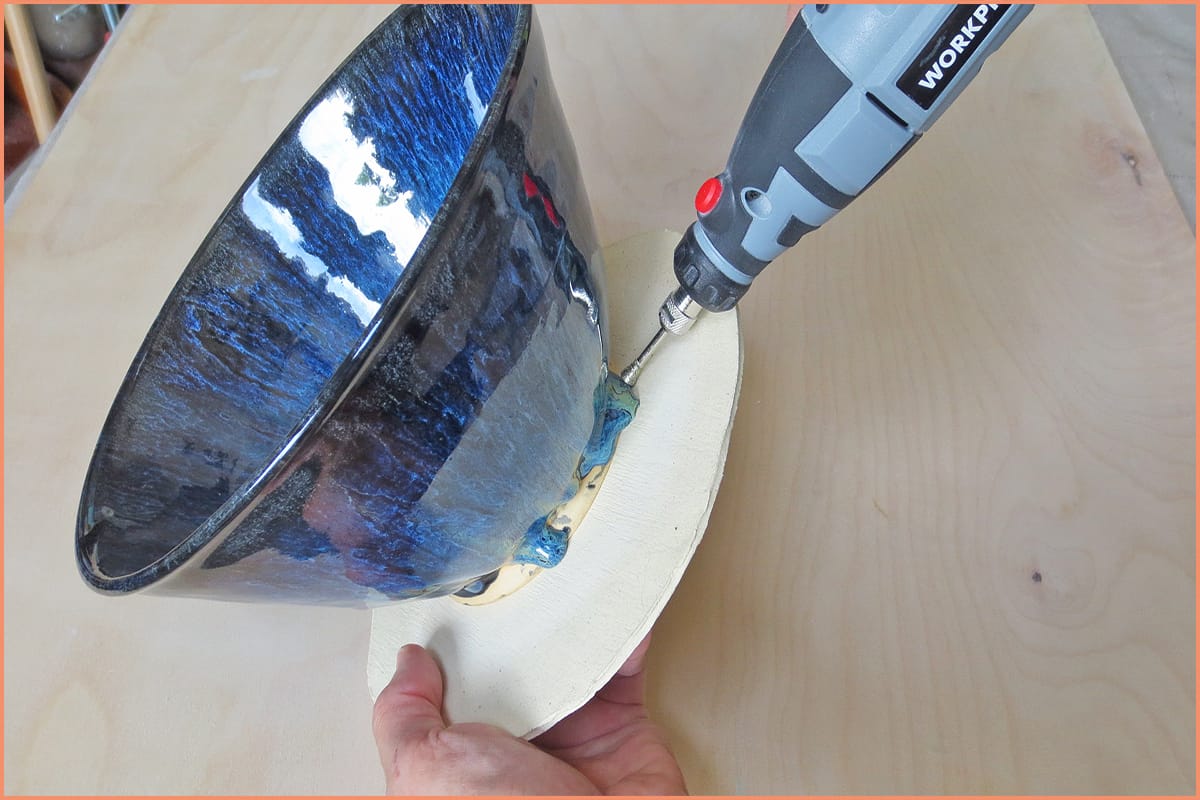 a picture of a potter removing glaze from a cookie