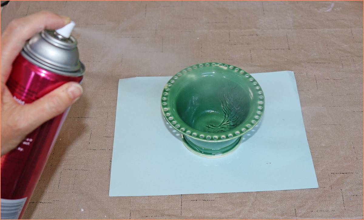 a potter spraying the inside of an earing holder