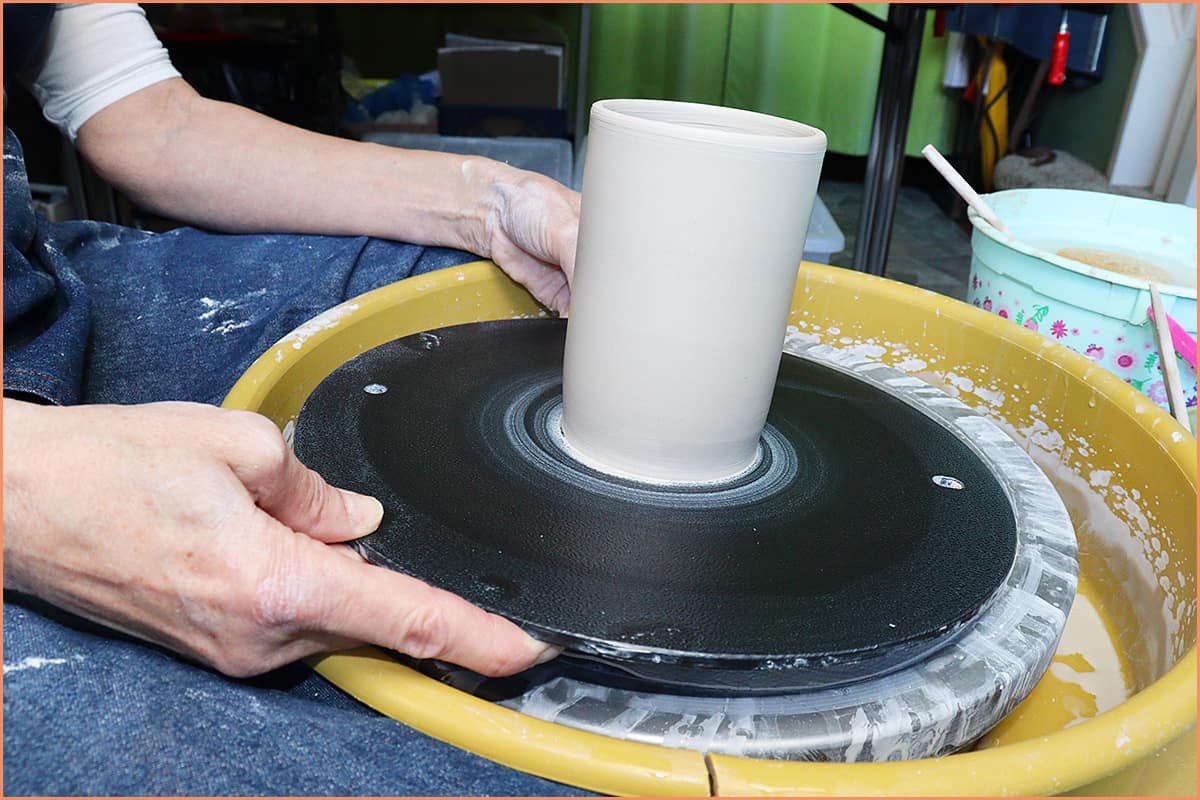 an image of a potter with a finished cylinder on bat