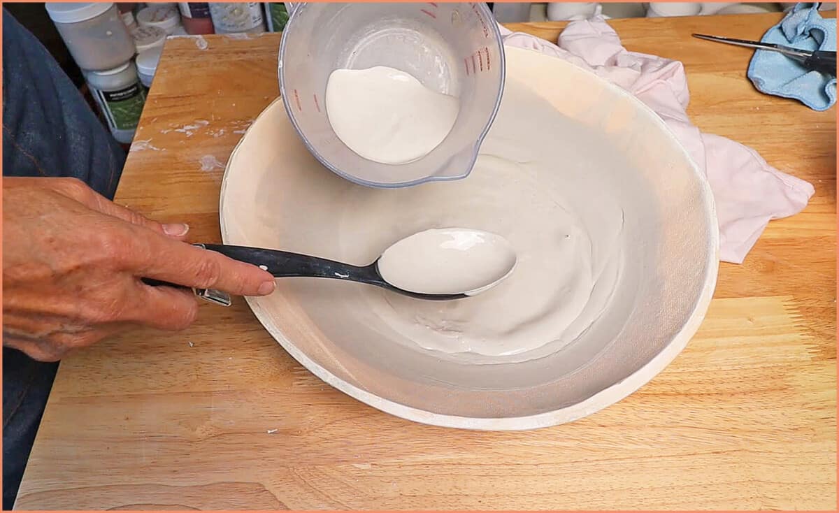 an image of a potter removing slip from bowl