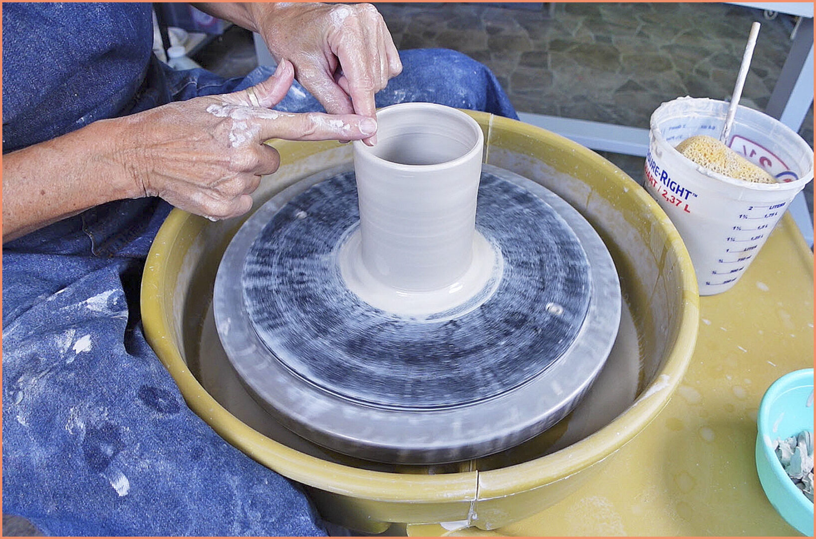 an image of a potter compressing the clay cylinder with your fingers