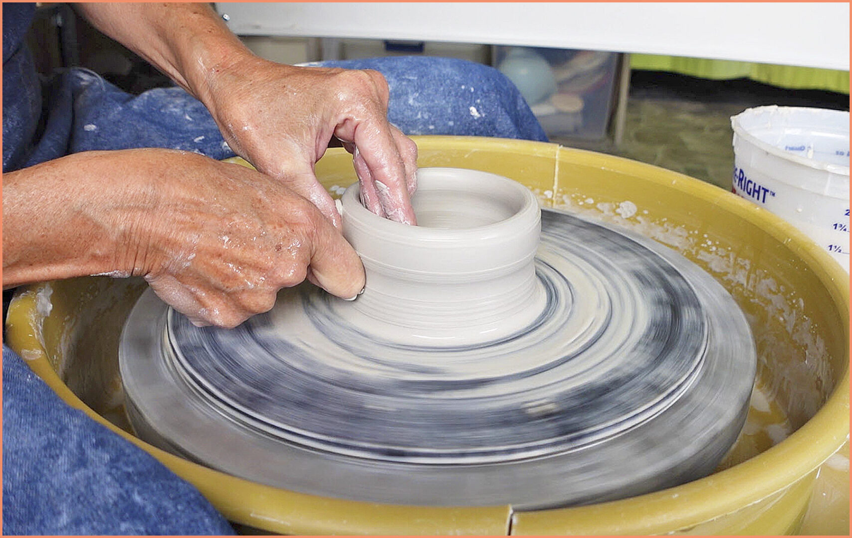 an image of a potter pulling up the walls using a knuckle